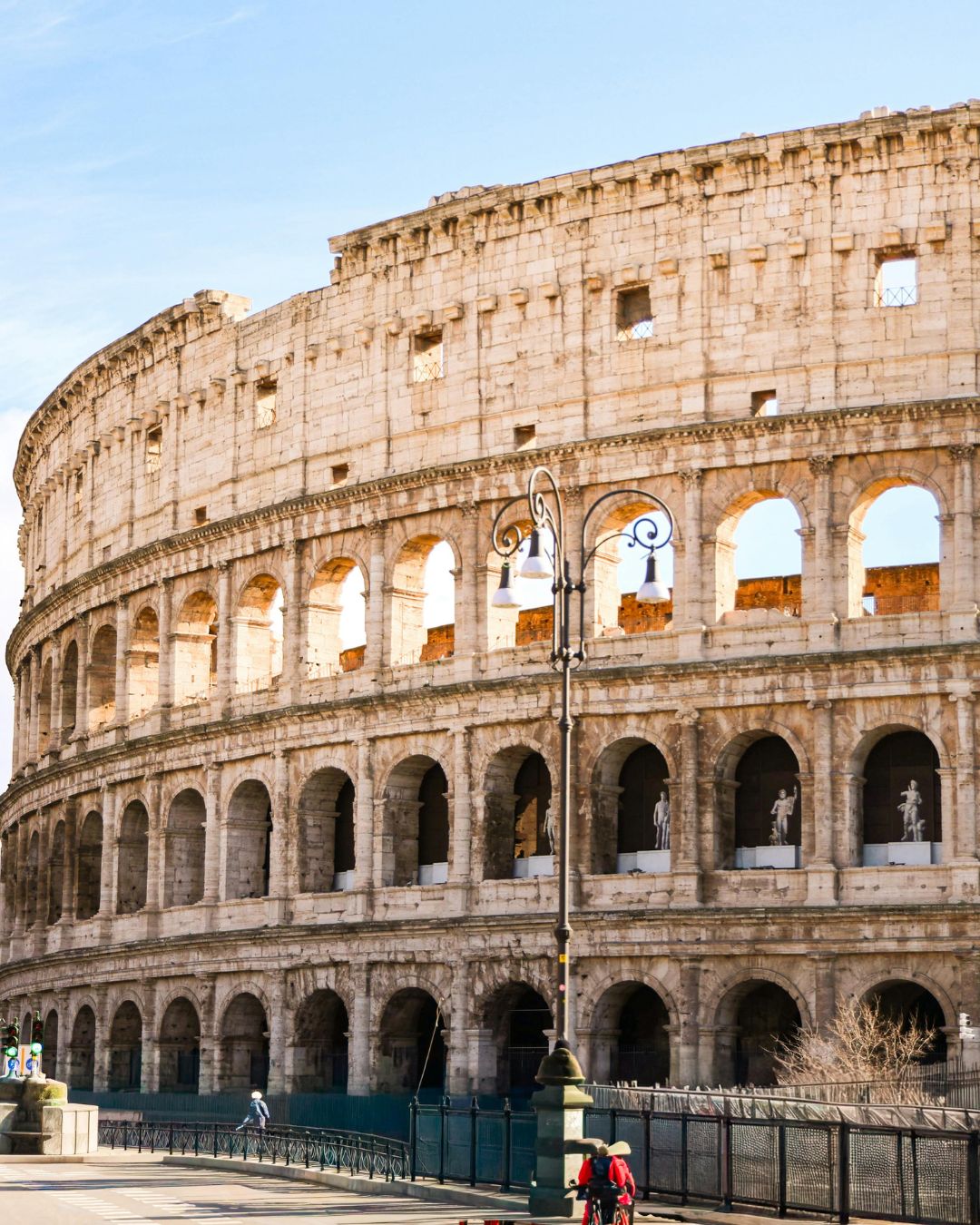 Senais Colosseum Romā ar arkām un tūristiem apkārt.