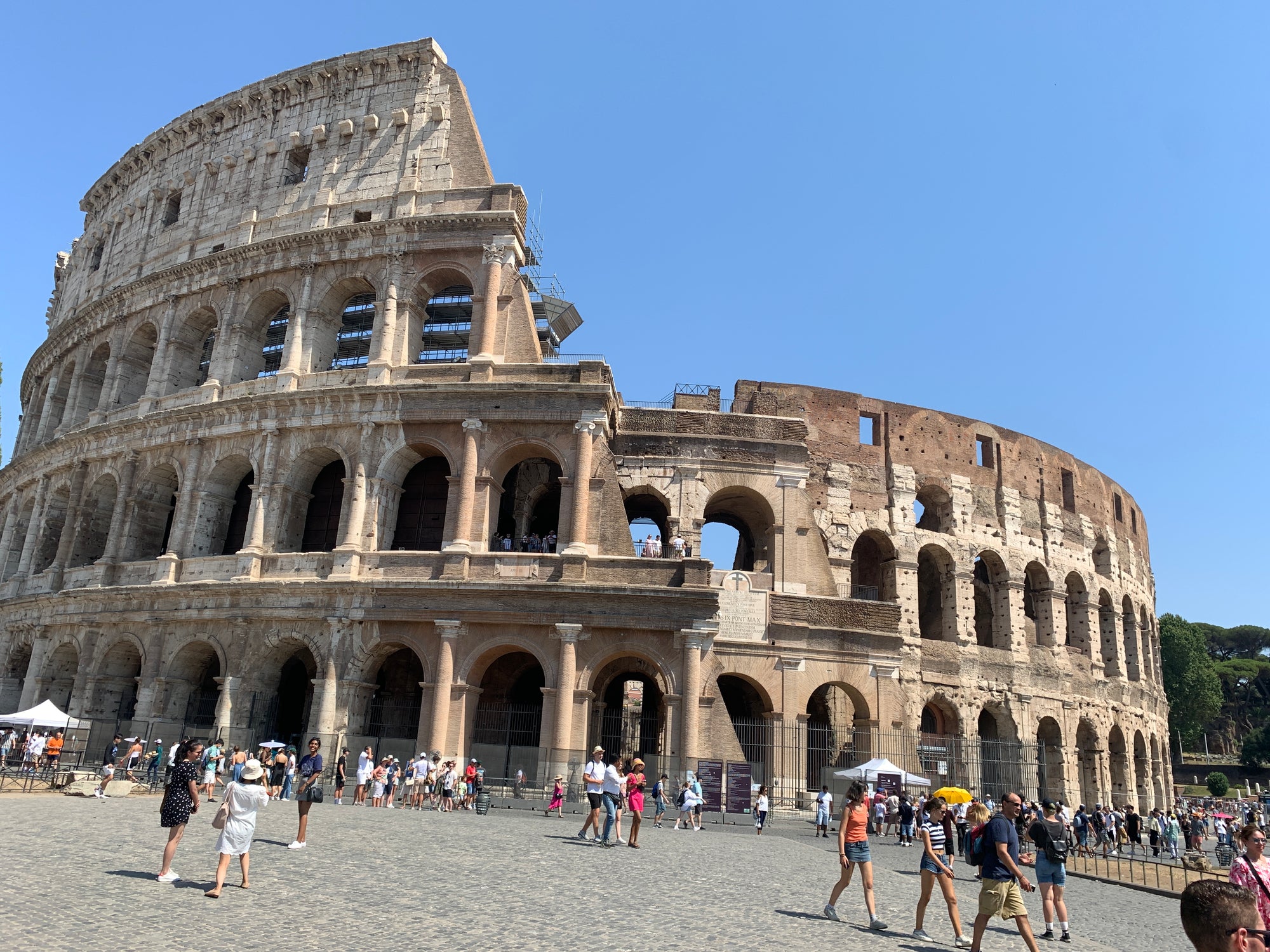 Senais Colosseum Romā ar arkām un tūristiem apkārt.